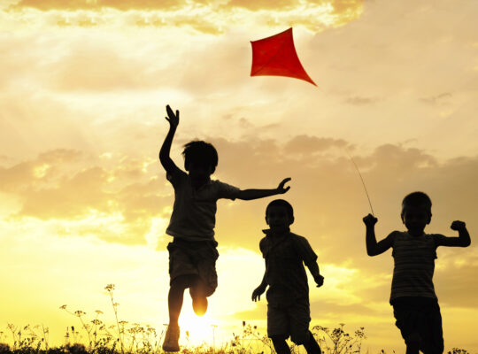 Children running with a kite