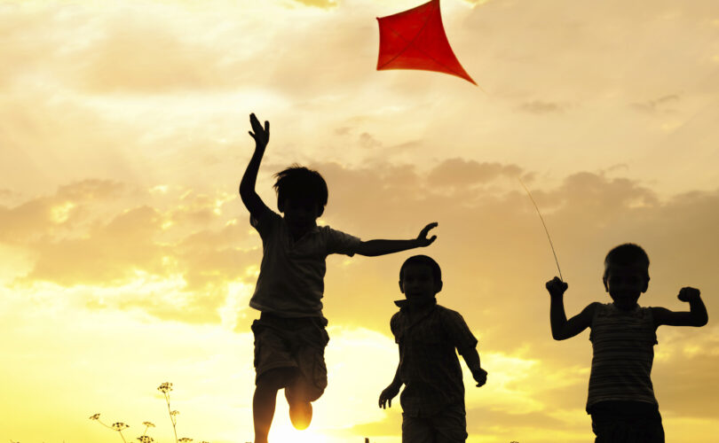Children running with a kite